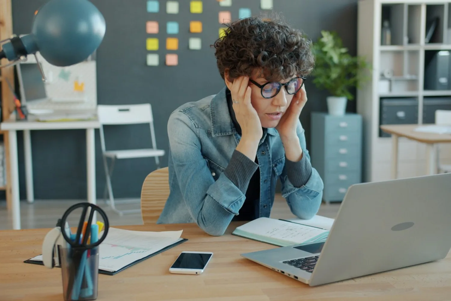A person checking a website outage alert on a laptop, confirming a site slowdown during peak BFCM traffic