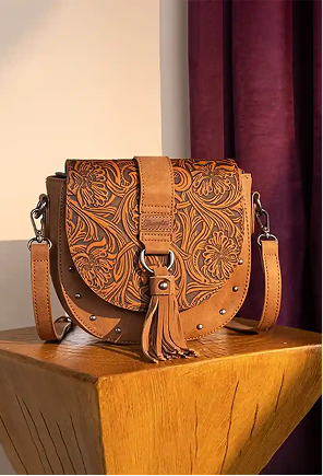 Montana West tooled leather crossbody saddle bag with tassel detail showcasing Western-style handbag craftsmanship